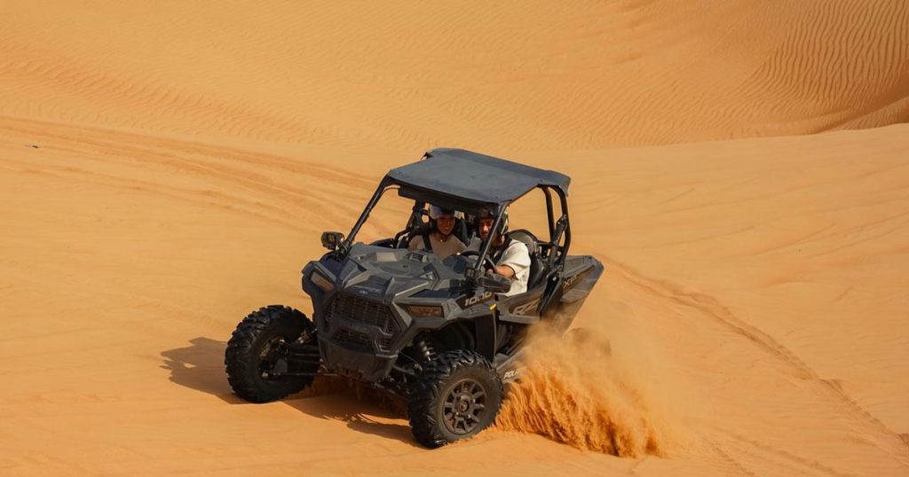 Person driving a high-power self drive dune buggy dubai in the desert Family Desert Buggy Tours Dubai