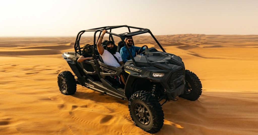 Can-Am buggy driving through Lahbab red sand dunes