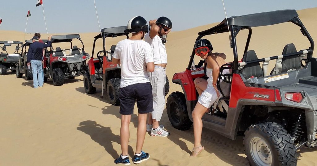 Tourist driving a self drive buggy in Dubai desert.