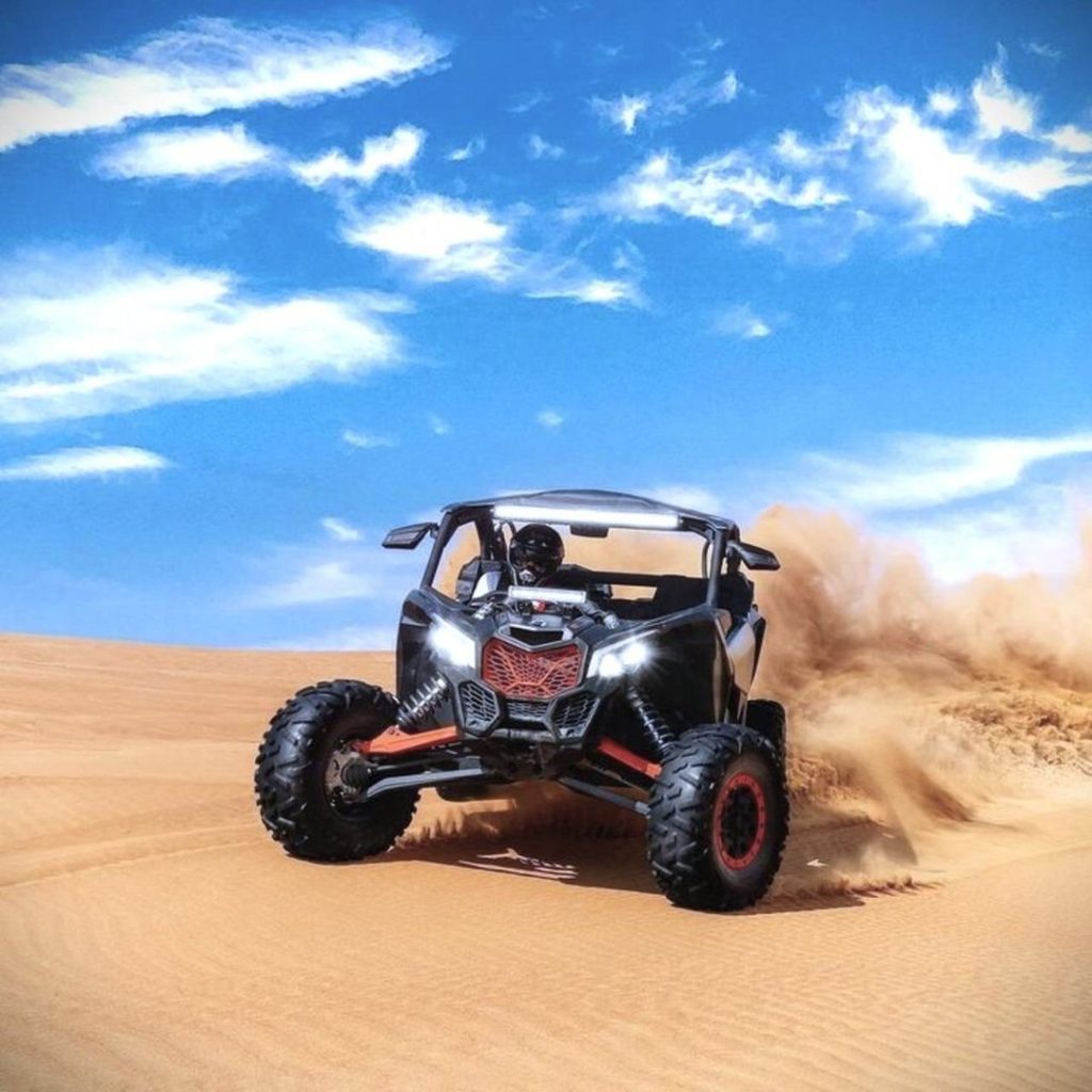 Tourists enjoying Can-Am dune buggy ride in Dubai desert